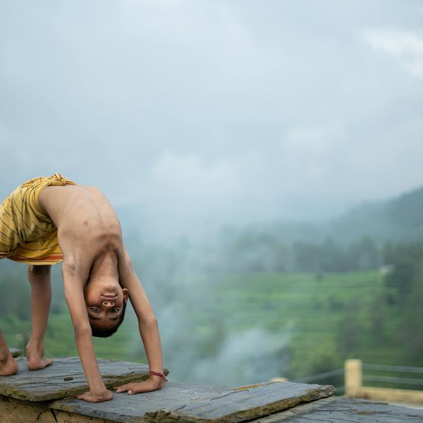 Person stretching outdoors with a serene landscape in the background.